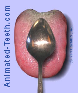 A picture of using a spoon as a tongue scraper.